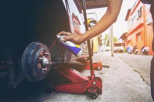 travailleur va mettre une nouvelle roue sur la voiture photo