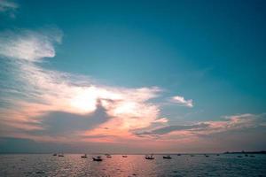 beau lever de soleil sur fond de mer avec bateau de pêche en bois tropical photo