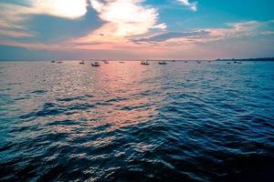 beau lever de soleil sur fond de mer avec bateau de pêche en bois tropical photo