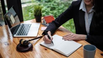 femme d'affaires ou avocats travaillant sur un bureau en bois au bureau. droit, services juridiques, conseils, vente aux enchères de juge et concept immobilier. photo