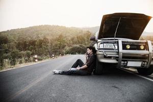 un homme essaie de résoudre un problème de moteur de voiture sur une route locale chiang mai thaïlande - les personnes ayant un problème de voiture concept de transport photo