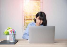 une jeune fille asiatique étudiait à la maison photo