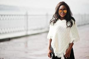 fille afro-américaine à lunettes de soleil posées en plein air. femme noire à la mode. photo