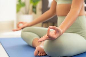 femme pratiquant le yoga respirant et méditant, faisant la pose de lotus avec un geste mudra. exercice de yoga pour le concept de bien-être photo