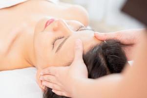 massage du visage. gros plan d'une jeune femme recevant un traitement de massage spa au salon spa. photo