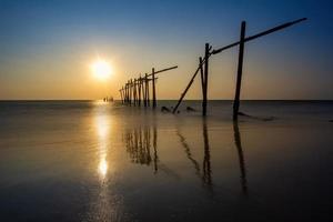 coucher de soleil et reflets de la mer, ponts en bois en décomposition, plage de khao pi lai phang nga, thaïlande photo