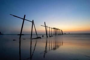 coucher de soleil et reflets de la mer, ponts en bois en décomposition, plage de khao pi lai phang nga, thaïlande photo