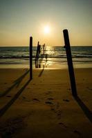 coucher de soleil et reflets de la mer, ponts en bois en décomposition, plage de khao pi lai phang nga, thaïlande photo