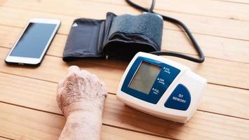 vieille dame est en cours de vérification de la pression artérielle à l'aide d'un moniteur de pression artérielle pour enfant - personnes avec concept d'ensemble d'instruments médicaux de soins de santé photo