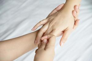 massage spa des mains sur fond de lit blanc propre - les gens se détendent avec un service de massage des mains