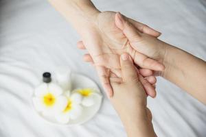 massage spa des mains sur fond de lit blanc propre - les gens se détendent avec un service de massage des mains photo