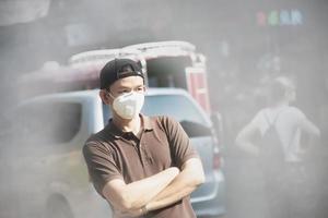 un homme portant un masque protège la poussière fine dans l'environnement de pollution de l'air - les personnes avec un équipement de protection pour le concept de pollution de l'air photo