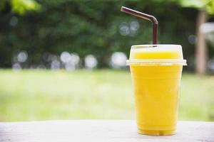 mélange d'orange de mangue glacée dans un jardin verdoyant - détendez-vous avec une boisson aux fruits froide dans le concept de la nature photo