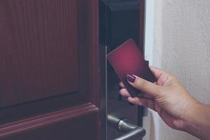 photo vintage d'une dame utilisant une carte-clé ouvrant la porte dans une chambre d'hôtel
