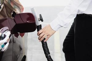 l'homme met du ngv, un véhicule au gaz naturel, un distributeur de tête dans une voiture à la station-service en thaïlande photo