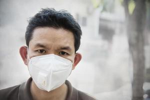 un homme portant un masque protège la poussière fine dans l'environnement de pollution de l'air - les personnes avec un équipement de protection pour le concept de pollution de l'air photo