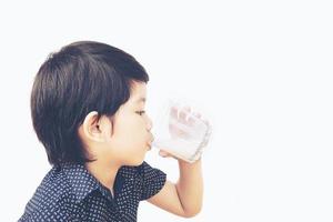 photo de style vintage d'un garçon asiatique boit un verre de lait