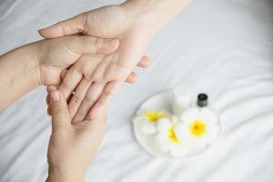 massage spa des mains sur fond de lit blanc propre - les gens se détendent avec un service de massage des mains