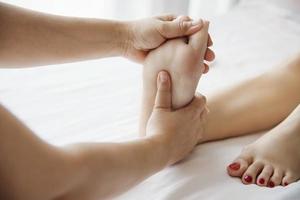 femme recevant un service de massage des pieds d'une masseuse en gros plan à la main et au pied - détendez-vous dans le concept de service de thérapie de massage des pieds photo