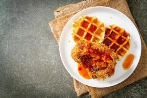 poulet frit avec gaufre et sauce épicée photo