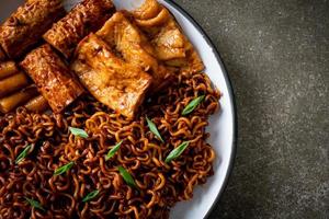 jajangmyeon ou jjajangmyeon avec odeng et omuk - nouilles instantanées coréennes avec gâteau de poisson coréen à la sauce aux haricots noirs photo