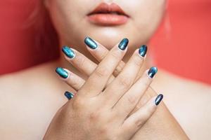 fille modèle de beauté avec des ongles de manucure verts. maquillage de mode femme et soin des mains cosmétiques. soins de santé. salon de beauté. peau propre et lisse, lèvres nues. main près du visage photo