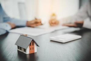 courtier conseiller consultant un client. l'agent immobilier offre la main au client signe la signature du contrat d'accord pour acheter ou vendre une maison. concept d'hypothèque d'entreprise et assurance habitation photo