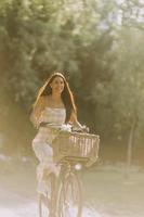 jeune femme avec des fleurs dans le panier de vélo électrique photo