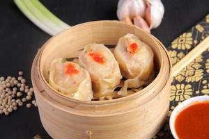 dim sum au poulet avec une délicieuse sauce, une cuisine chinoise savoureuse et juteuse photo