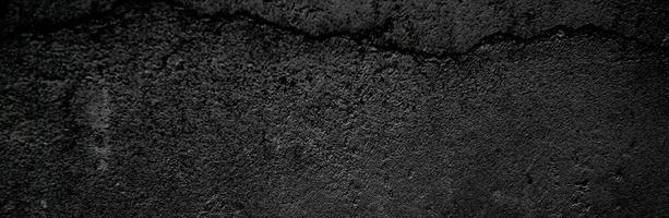 fond panoramique de texture de béton noir et gris. murs sombres effrayants, texture de ciment en béton noir légèrement clair pour le fond. surface sombre grunge paysage panoramique photo