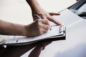 homme travaillant avec la liste de contrôle d'entretien de voiture - personnes avec concept d'entretien de voiture photo