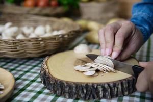 dame cuisine des légumes champignons champignons frais dans la cuisine - personnes avec concept de cuisine végétale photo