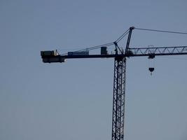 grue au travail sur un chantier transportant des matériaux photo