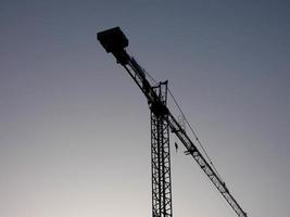 grue au travail sur un chantier transportant des matériaux photo