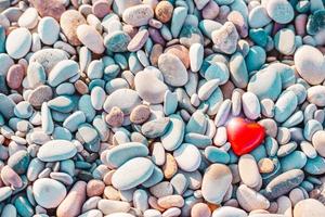 symbole romantique du coeur rouge sur la plage de galets photo