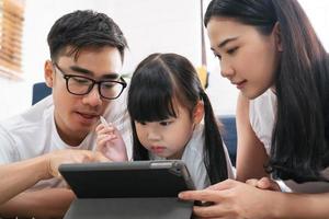 fille utilisant la technologie de l'éducation d'apprentissage de la tablette avec la famille. photo