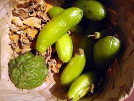 une variété d'épices pour la cuisine servies dans un récipient en bambou tressé comme le curcuma, le gingembre, le bilimbi et le citron vert. photo