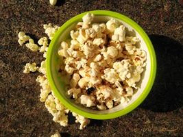 vue en hauteur du pop-corn mûr servi dans un bol vert.gros plan .en plus de vous aider à perdre du poids, manger du pop-corn a également d'autres avantages pour la santé. photo