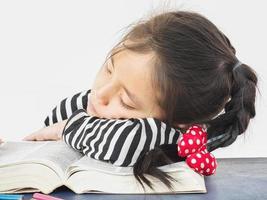 un enfant asiatique dort en lisant un gros livre photo