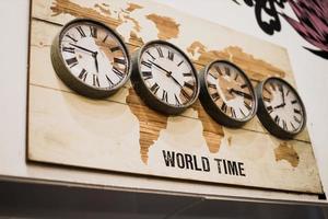 quatre horloges murales de fuseau horaire montrant différentes heures dans le monde avec un design vintage. photo