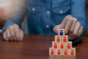 femme choisit le leader du succès pour les affaires en ligne. cube en bois sur table photo