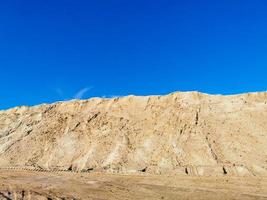 une montagne de sable jaune humide et un ciel bleu clair photo