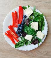 petit-déjeuner frais et coloré avec myrtilles, légumes verts et rouges et fromage cambazzola photo