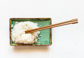 riz bouilli avec des baguettes sur une assiette blanche photo