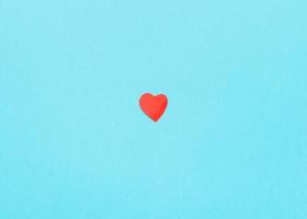 coeur coupé en papier rouge sur papier bleu turquoise photo