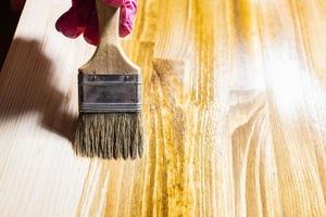 la planche de bois est recouverte de teinture à bois en gros plan photo