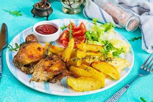 délicieux poulet au four avec pommes de terre sur fond bleu photo