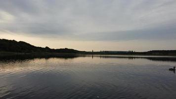 image aérienne et en grand angle de jolis oiseaux d'eau nagent dans le lac stewartby d'angleterre royaume-uni par beau petit matin au lever du soleil photo