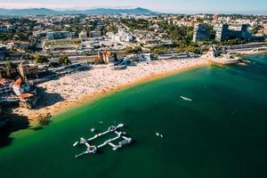 vue aérienne de la plage duquesa à cascais, portugal pendant l'été. les gens jouent dans l'eau photo