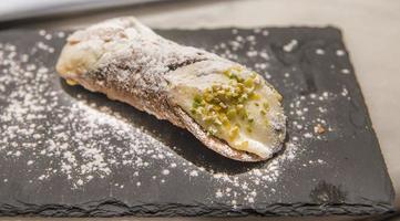 cannoli est un dessert de sicile, italie composé de fromage ricotta, de sucre en poudre et de pistache photo